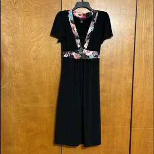 Like new! Wore once. Beautiful black dress with satin material floral sash. L